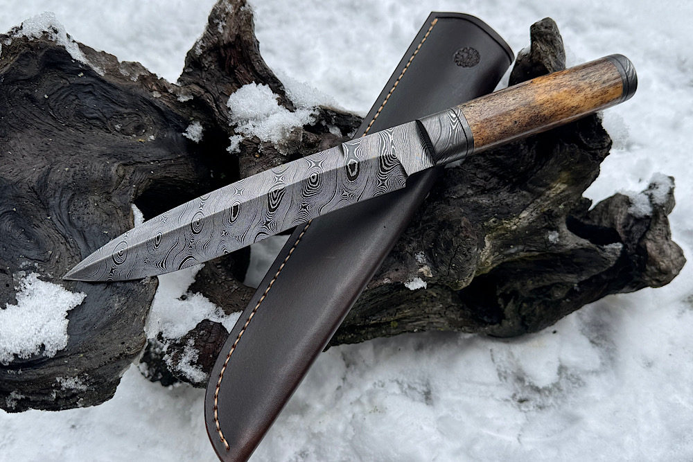 Big Schmidbauer Hunter mit einem Griff aus Oosik mit Cites in selten schöner Farbe. Klinge aus Messerwerk Damast. Klingen Härte 61 HRC, Klingen Länge 178 mm, Gesamtlänge 295 mm. Auf Anfrage 