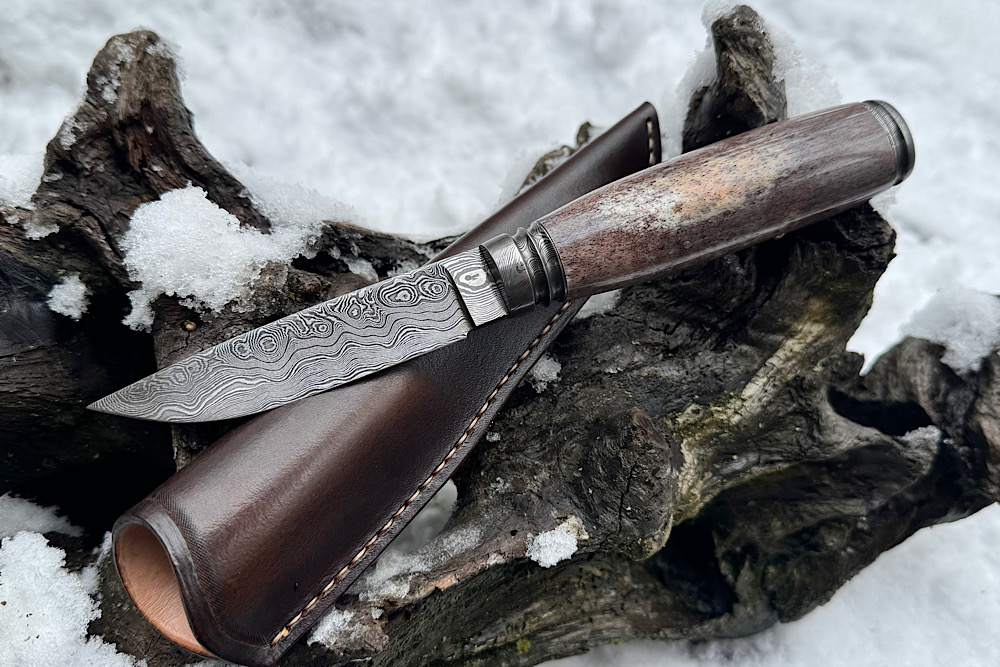 Oosik Hunter mit einem Griff aus Oosik mit Cites in selten schöner Farbe. Klinge aus Messerwerk Damast. Klingen Härte 61 HRC, Klingen Länge 97 mm, Gesamtlänge 226mm. Auf Anfrage